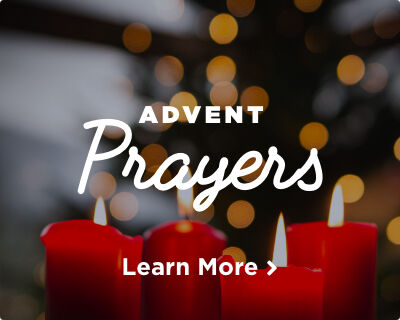 Four red candles burning, with flickering flames and twinkling festive lights in the background. Image links to Advent Prayers page.